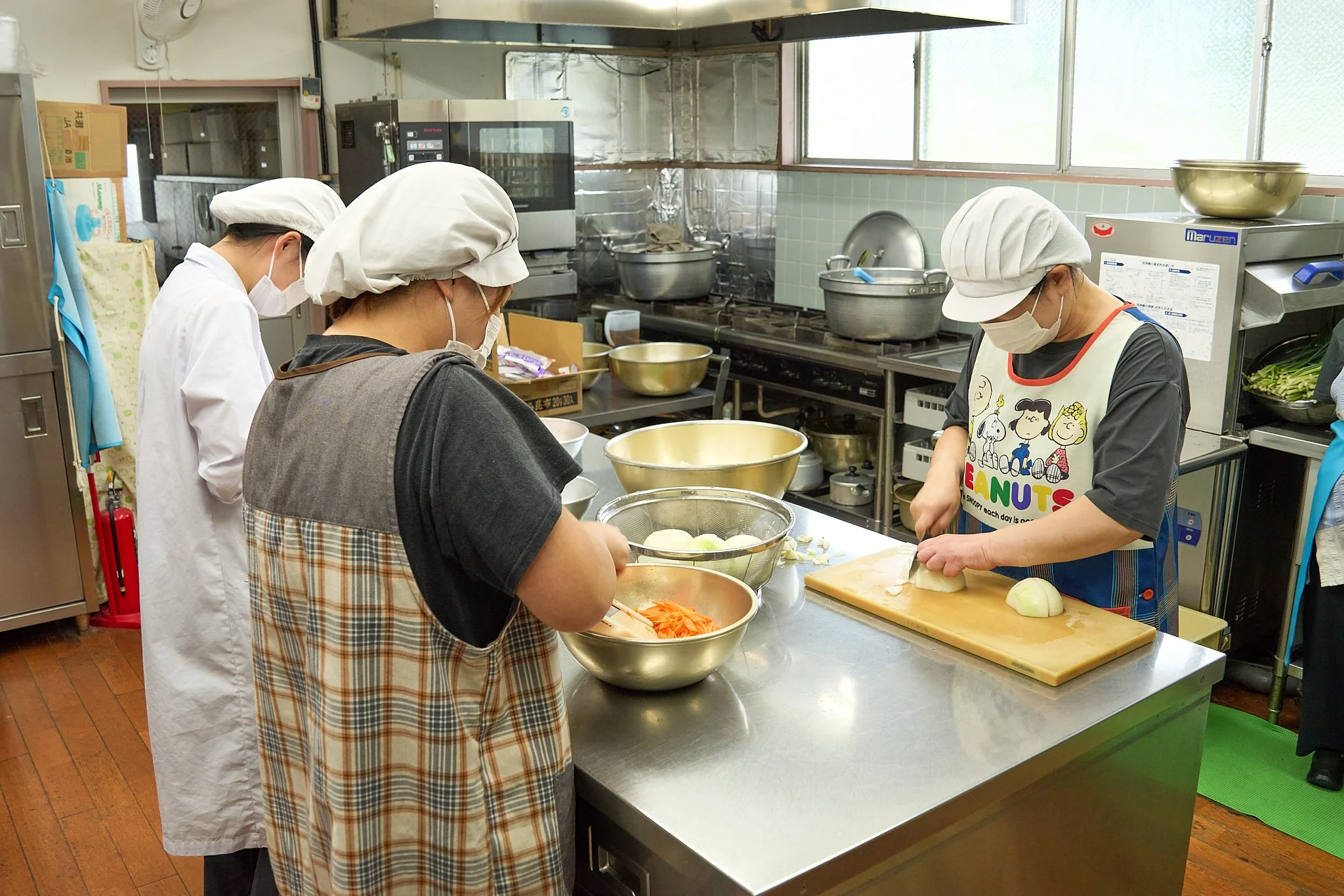 給食室で野菜を切る調理員